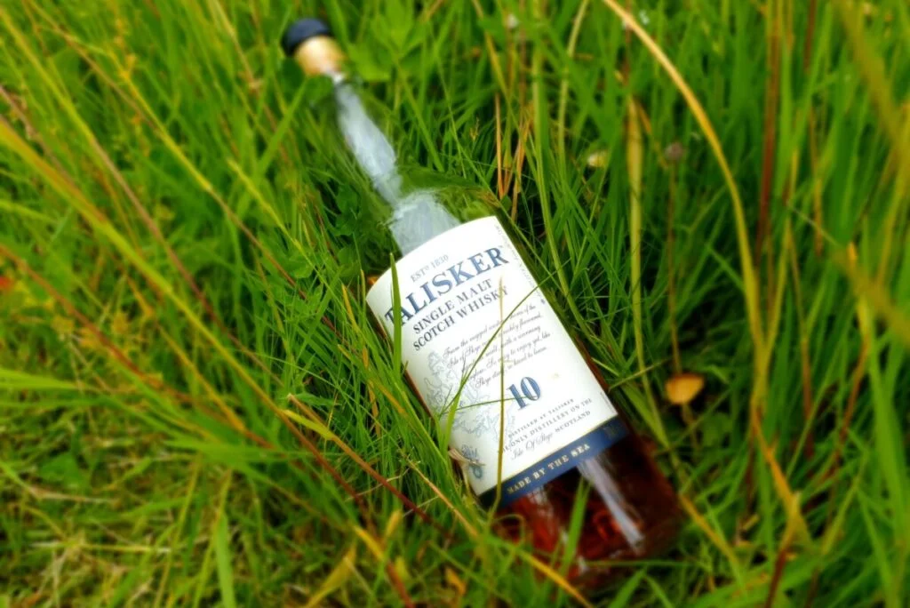 A bottle of talisker 10 in a field of grass