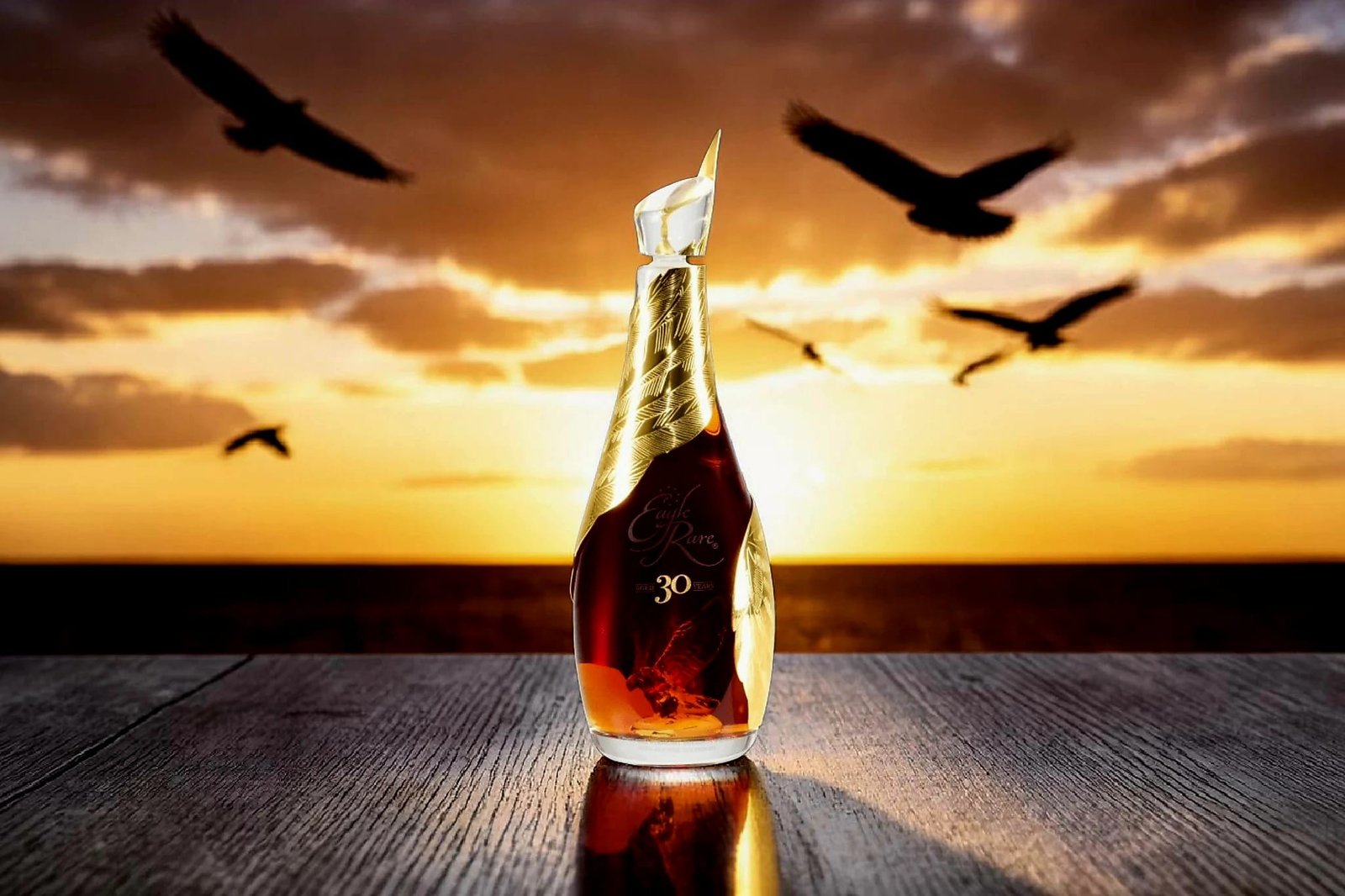 Eagle Rare 30 bourbon bottle at sunset with eagles flying in the Kentucky sky