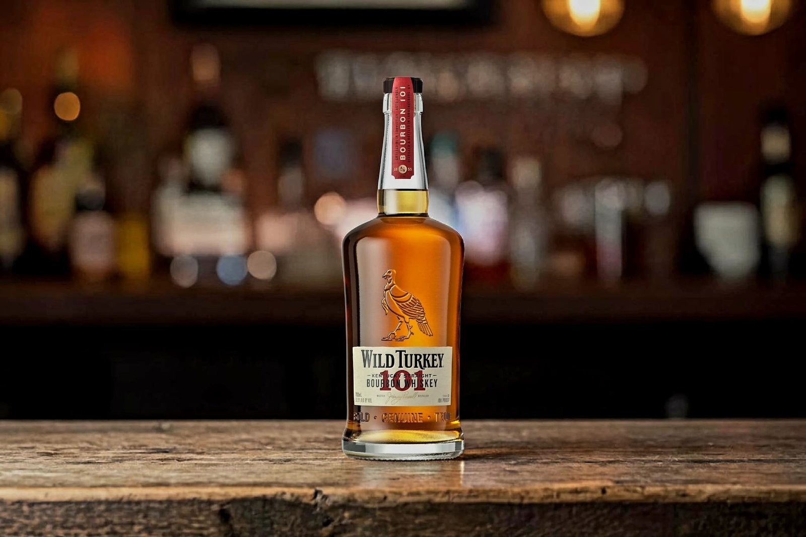 Wild Turkey 101 bourbon bottle on wooden bar with warm background lighting