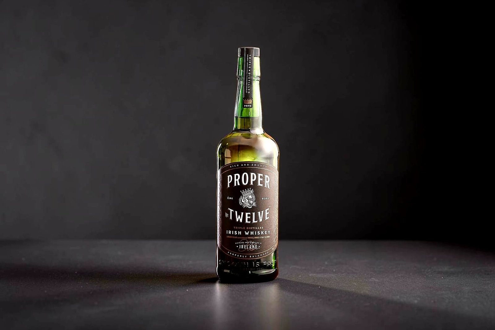 Bottle of Proper No. Twelve Irish Whiskey photographed against a dark studio background.