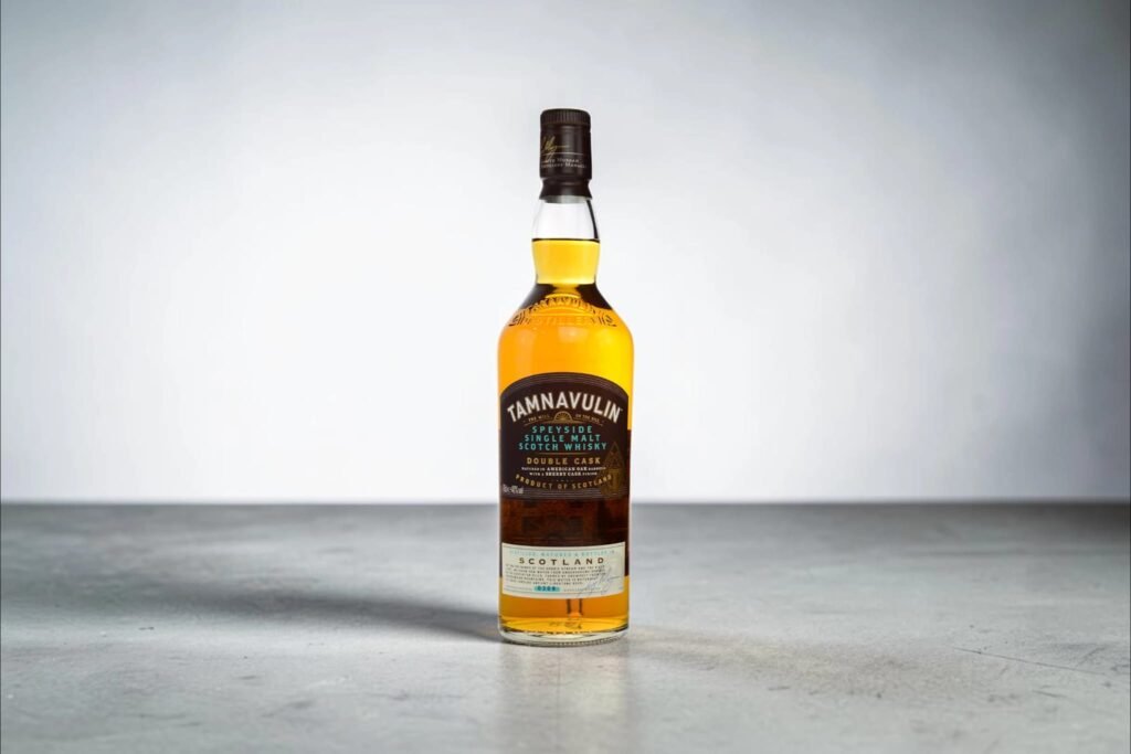 Tamnavulin Double Cask Review: Speyside single malt Scotch whisky bottle standing on a grey surface against a minimalist background