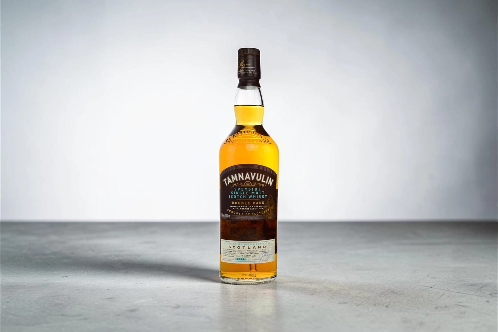 Tamnavulin Double Cask Review: Speyside single malt Scotch whisky bottle standing on a grey surface against a minimalist background